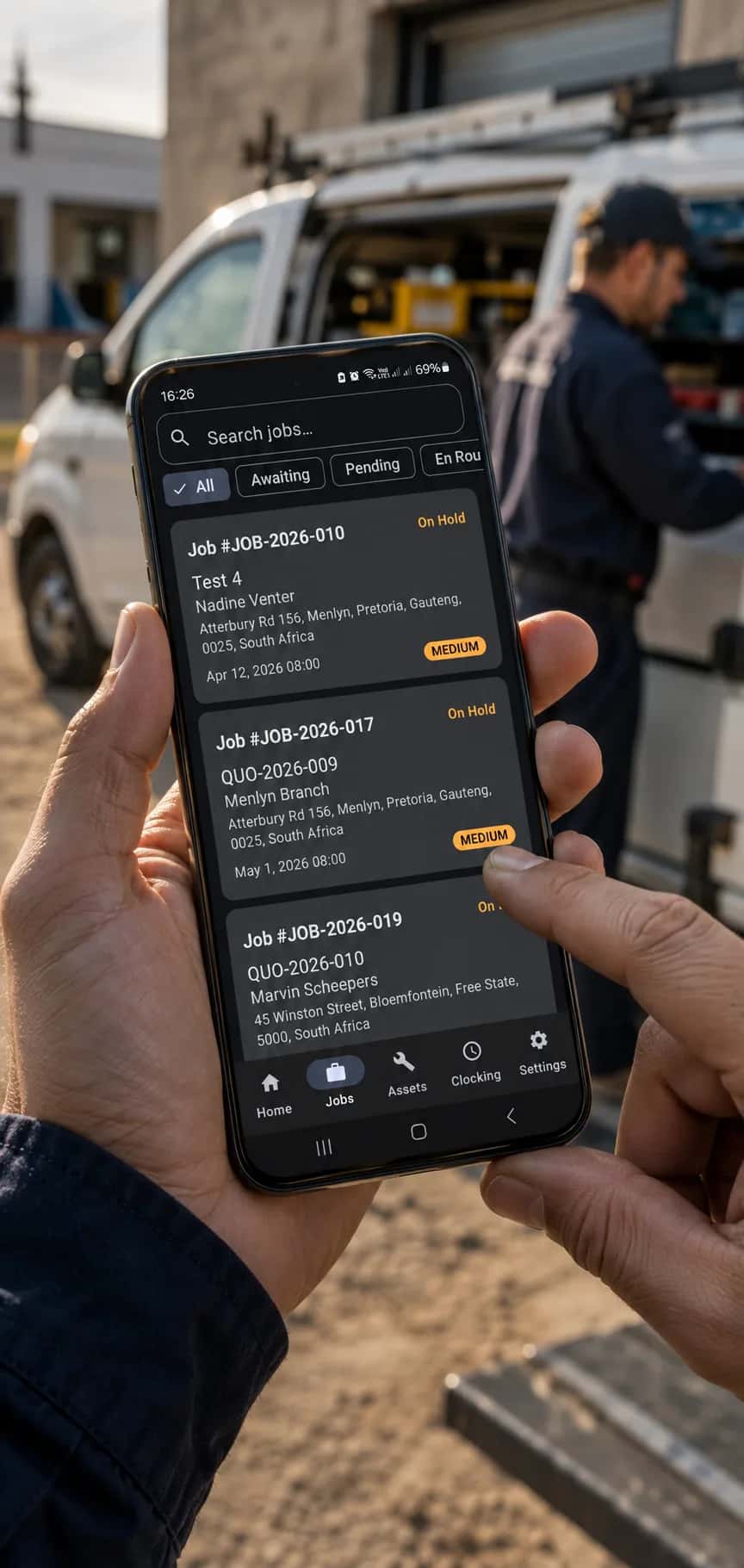 Technician at the back of a service van looking at a phone, with a diagram of connected modules syncing to the cloud beside him